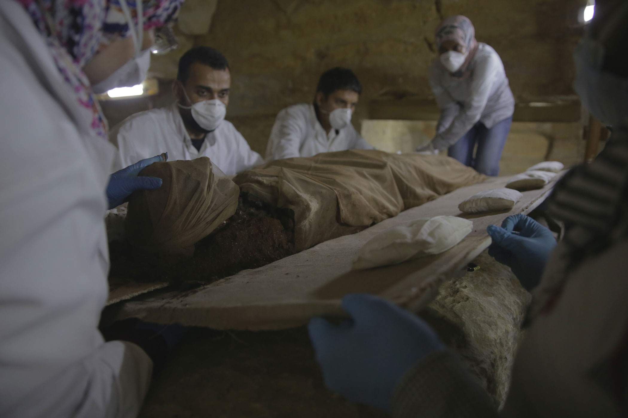 Saqqara, Egypt - Wrapped in a protective shroud, the mummy of Tadihor is delicately moved onto a board to prepare her remains for x-ray. This next chapter in Tadihor's story should unveil even more clues about her long-forgotten identity. [credit: foto di Barney Rowe; Copyright National Geographic]