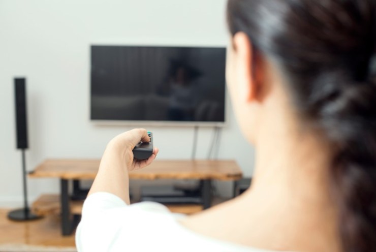 Una ragazza che accende la tv